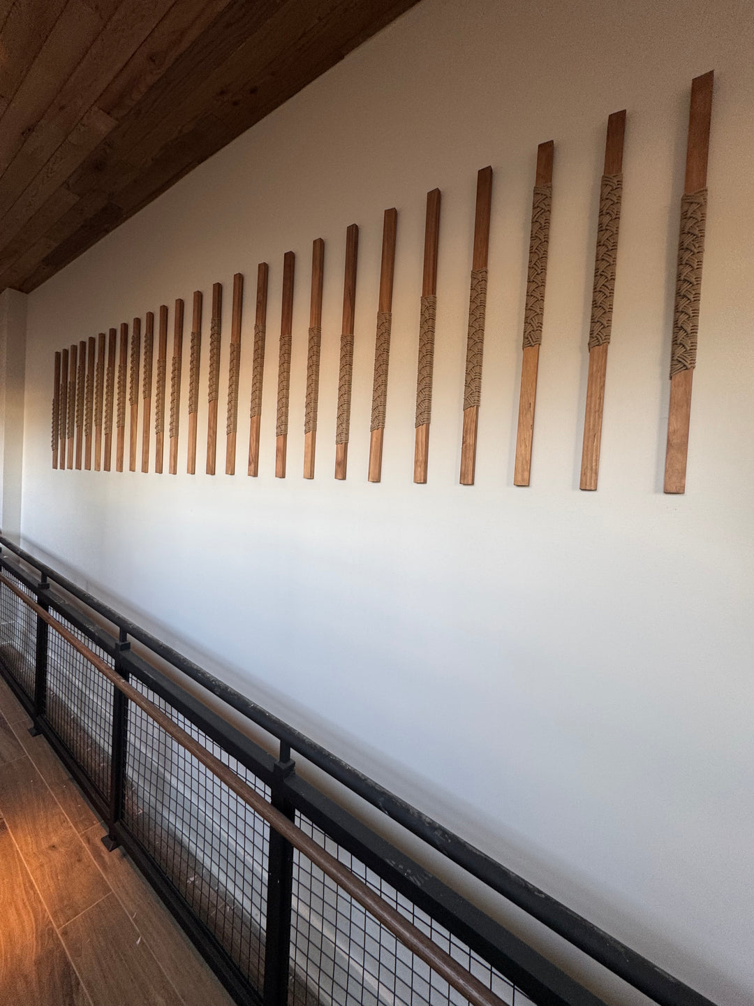Wooden slats on a white ceiling with a metal grid structure below