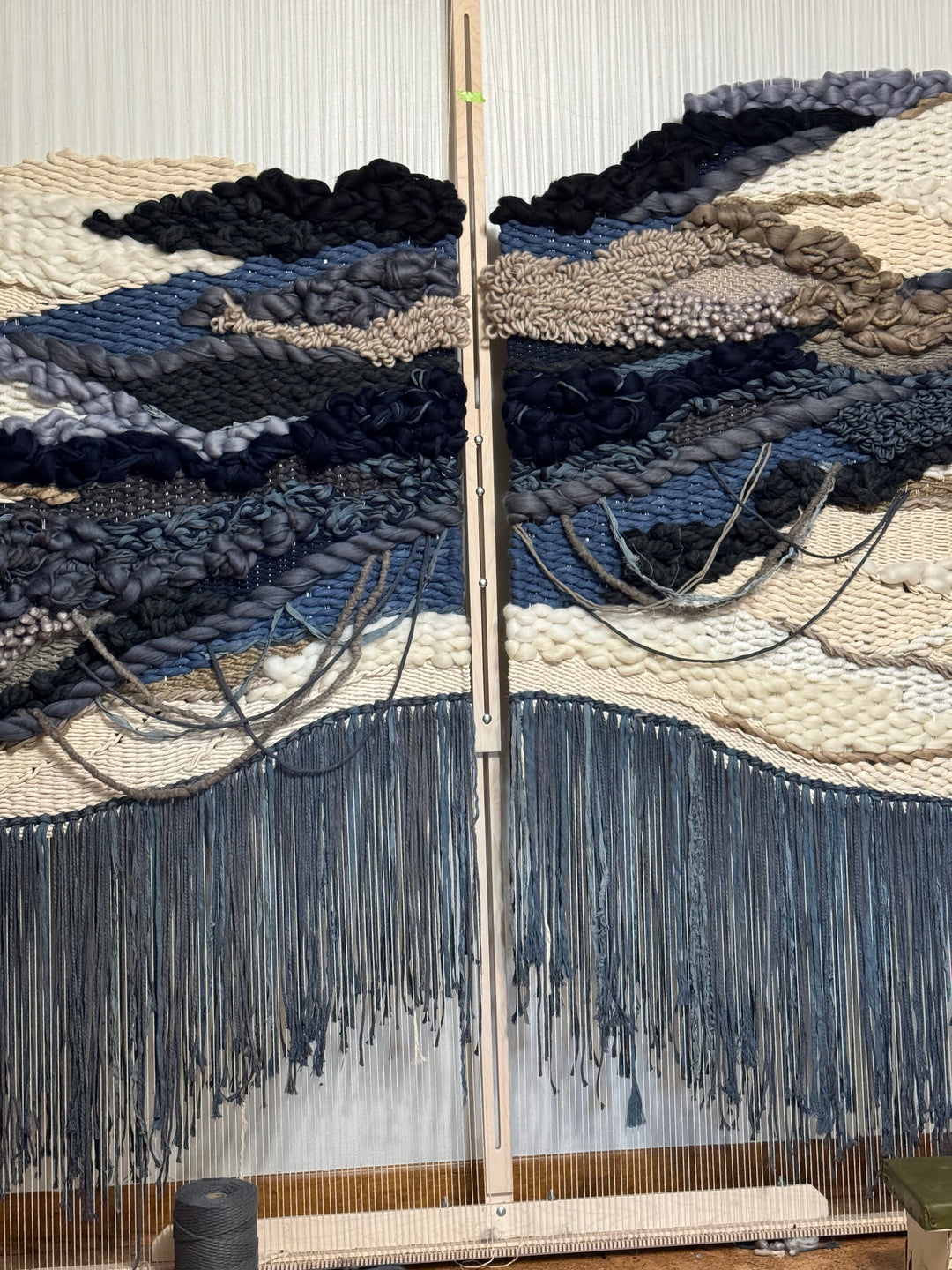 Textile with blue and black patterns on a loom