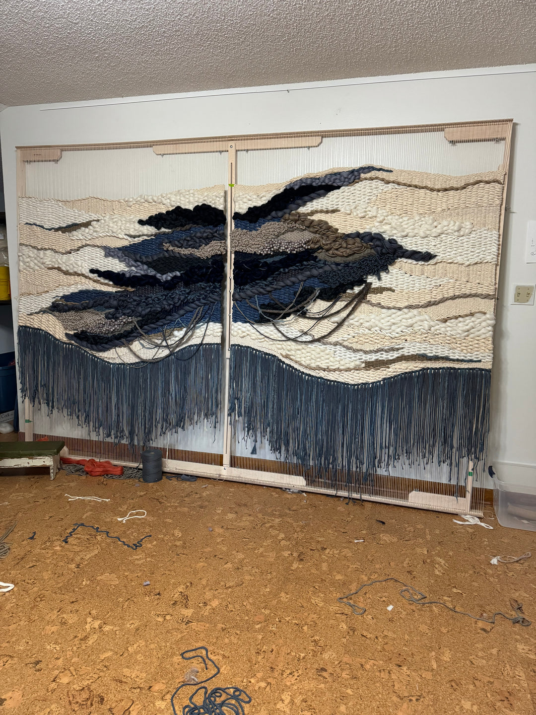 Textile art piece with blue and white patterns symbolic of the ocean