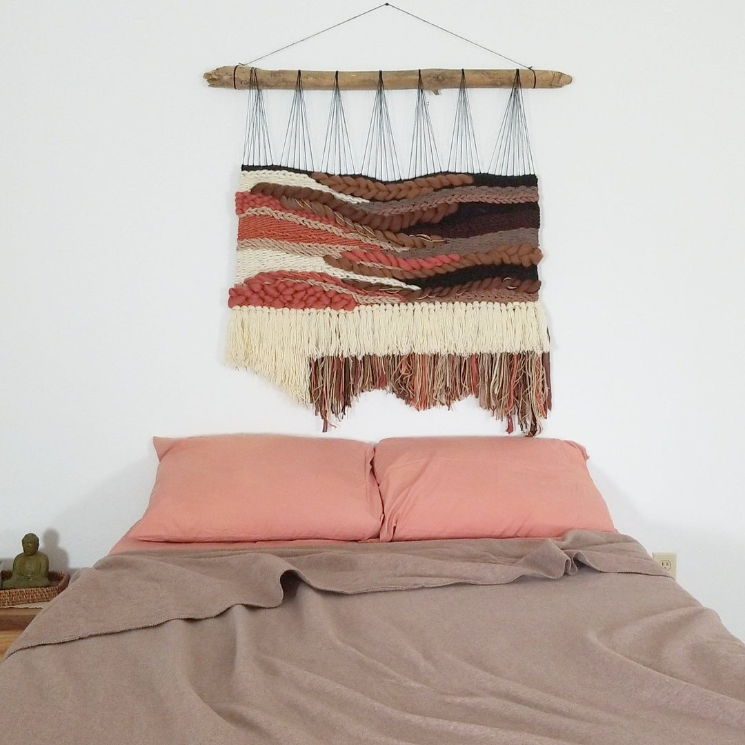 woven wall hanging above bed